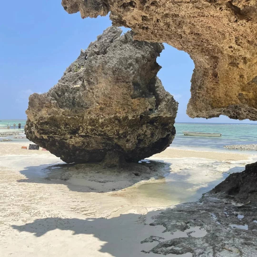 A natural coral arch on the beach at low tide